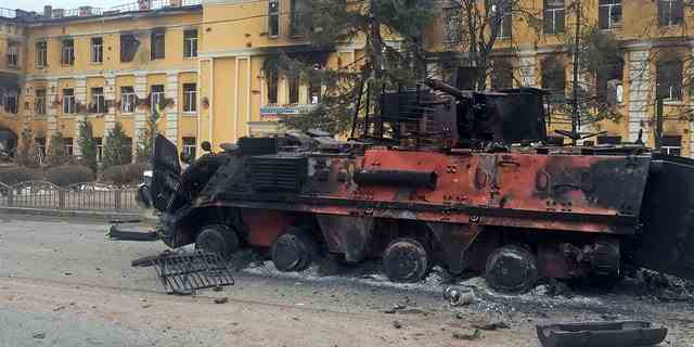 Ein zerstörtes gepanzertes Fahrzeug ist am 28. Februar 2022 in Charkiw, Ukraine, vor einer Schule zu sehen, die nach Angaben von Anwohnern nach dem Beschuss in Flammen stand, während Russlands Invasion in der Ukraine andauert. 