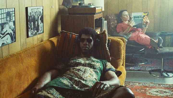 Solomon Hughes als Kareem Abdul-Jabbar ruht sich in einer Szene aus HBOs Winning Time auf einer Couch aus.