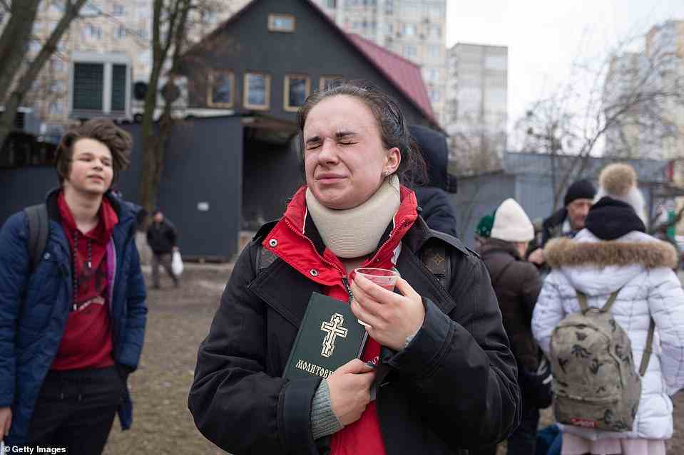 A woman who has just been safely evacuated from Irpin prays for those people who have stayed in the city as it is targeted by Russian shells