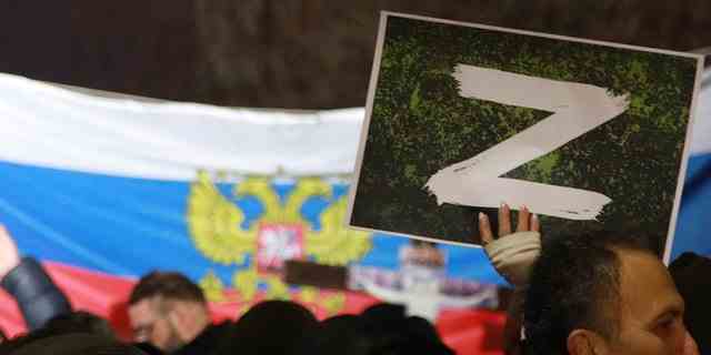 Ein Demonstrant hält a "Z" Zeichenbanner, in Bezug auf russische Panzer, die mit dem Buchstaben gekennzeichnet sind, während einer Kundgebung, die von serbischen rechtsgerichteten Organisationen zur Unterstützung russischer Angriffe auf die Ukraine am 4. März 2022 in Belgrad, Serbien, organisiert wurde. Rund tausend serbische ultranationalistische Unterstützer marschierten in Belgrad zur Unterstützung der russischen Angriffe auf die Ukraine.