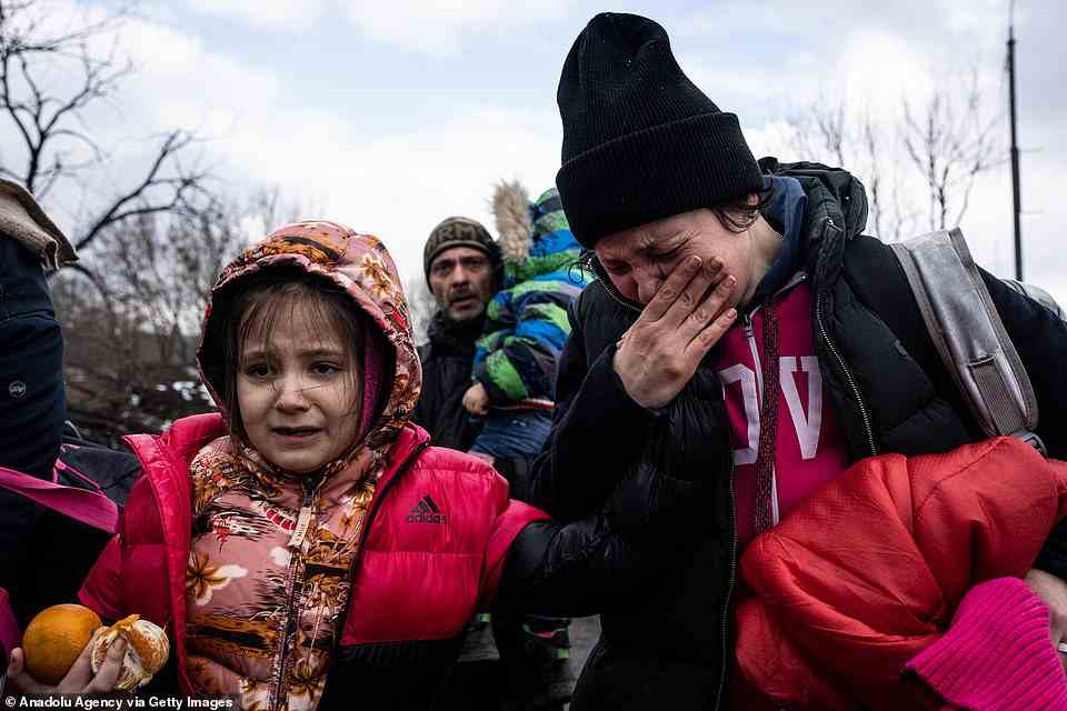 A police officer says goodbye to his son as his family flees from advancing Russian troops as Russia's attack on Ukraine continues in the town of Irpin