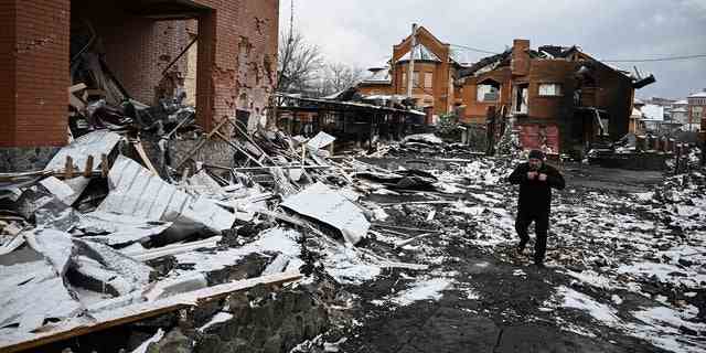 Ein Mann geht zwischen Häusern hindurch, die bei Luftangriffen auf die zentralukrainische Stadt Bila Zerkwa am 8. März 2022 zerstört wurden.