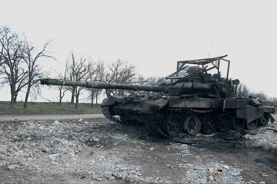 A Russian tank with overhead armour meant to protect against American-made javelin missiles is pictured burned-out by the side of a road in Ukraine, after the makeshift protection apparently failed