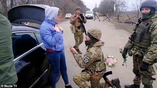 Der Soldat hält um ihre Hand an, während seine Kameraden zusehen