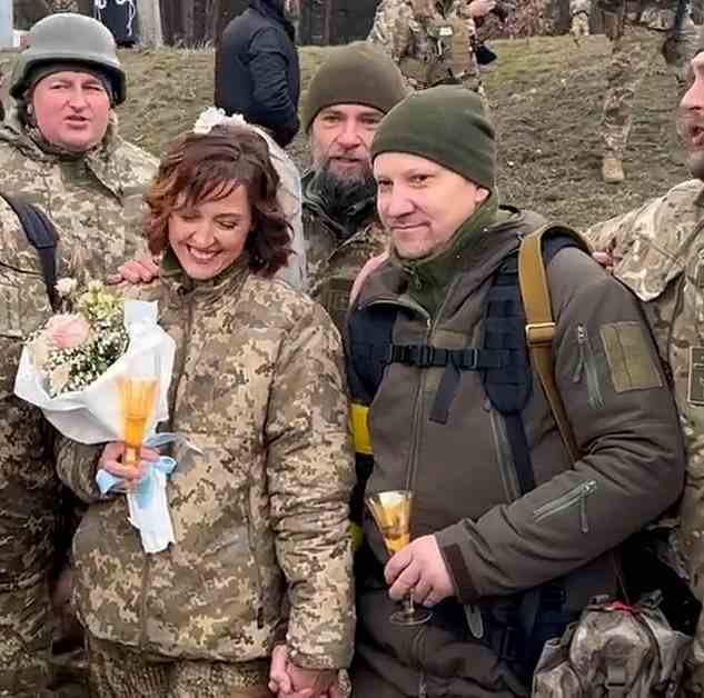 Ein anderes Paar entschied sich, den Bund fürs Leben zu schließen, während beide ihr Land im Krieg verteidigten;  Die neue Braut Lesya hält einen Blumenstrauß in der Hand, während Valeriy, ihr frischgebackener Ehemann, eine Champagnerflöte in der Hand hält