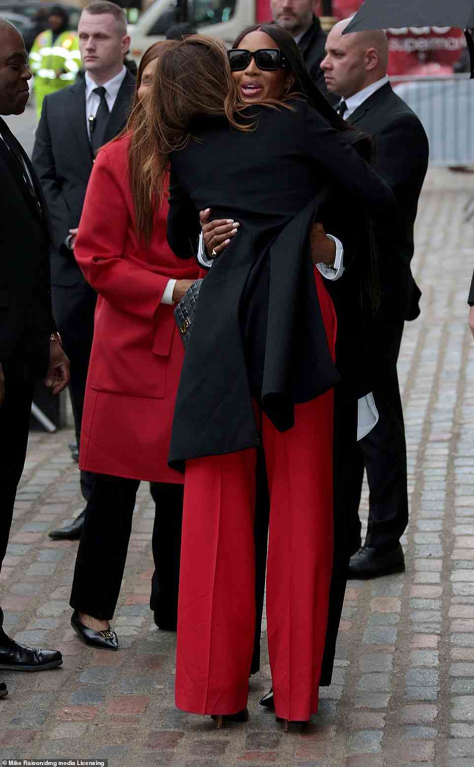 Famous pals: Naomi also embraced Italian-French singer-songwriter Carla Bruni, 54, who looked effortlessly chic in a pair of high waisted red trousers