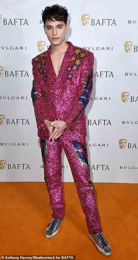 Eye-popping: Max Harwood ensured he was the centre of attention in a glittery pink suit which featured dazzling gold stars and multi-coloured rocket prints, while keeping things casual with a pair of tan trainers