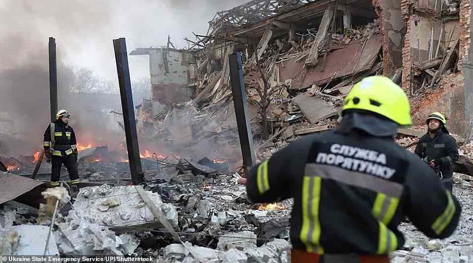 Rescuers work at the scene of an airstrike in Dnipro during the first shelling of the Ukrainian city that killed a security guard