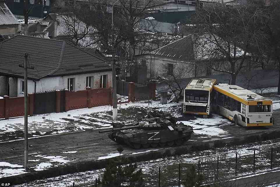 A Russian army tank marked with a Z moves through the outskirts of Mariupol, a city that continues to be pounded by shelling after Moscow widened its offensive in Ukraine