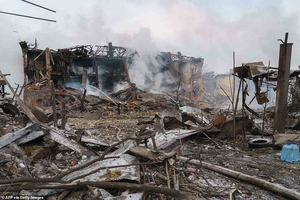 Firefighters spray water on a destroyed shoe factory following an airstrike in Dnipro after civilian targets came under Russian shelling