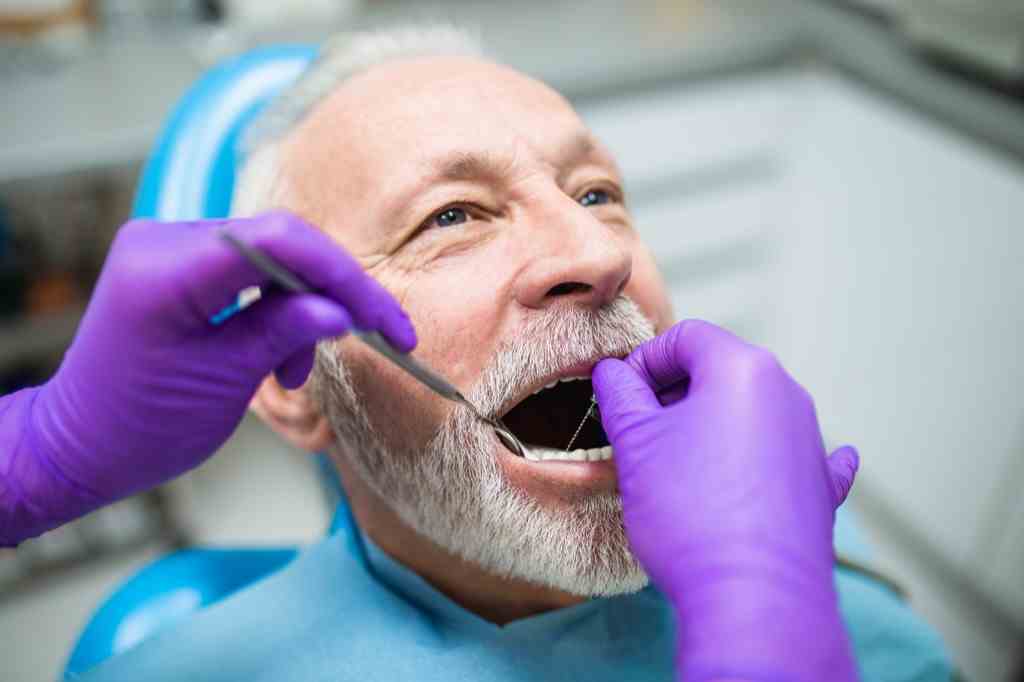 Älterer Mann beim Zahnarzt beim Zahnfleischcheck, Gesundheitsfragen ab 40