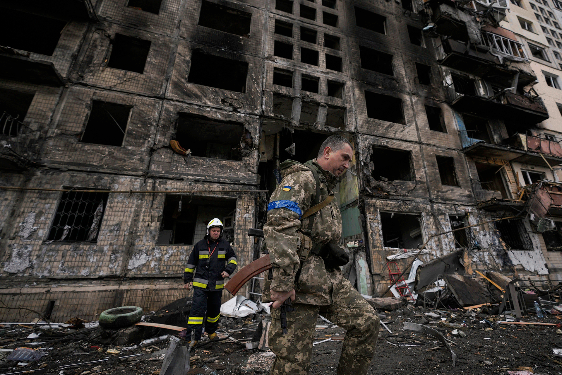 Ukrainische Soldaten und Feuerwehrleute suchen in einem zerstörten Gebäude nach einem Bombenanschlag in Kiew, Ukraine, Montag, 14. März 2022. 