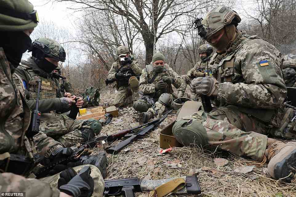 Members of the Ukrainian Territorial Defense Forces load magazines during tactical exercises near Lviv in western Ukraine as they prepare to face Russian forces advancing from the east