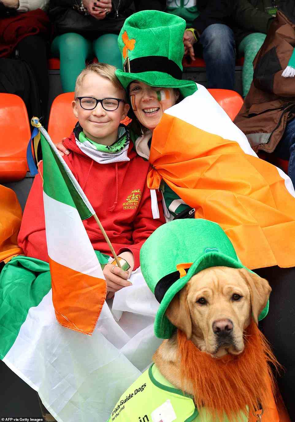 Deirdre Betson, her son Alex and Alfie, an Irish guide dogs for the blind puppy in training, enjoy the annual St Patrick's Day parade in Dublin