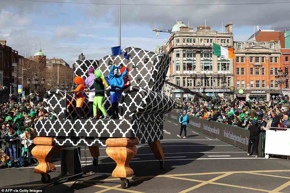 Performers standing on a giant chair cross O'Connell bridge during the annual St Patrick's Day parade in Dublin today