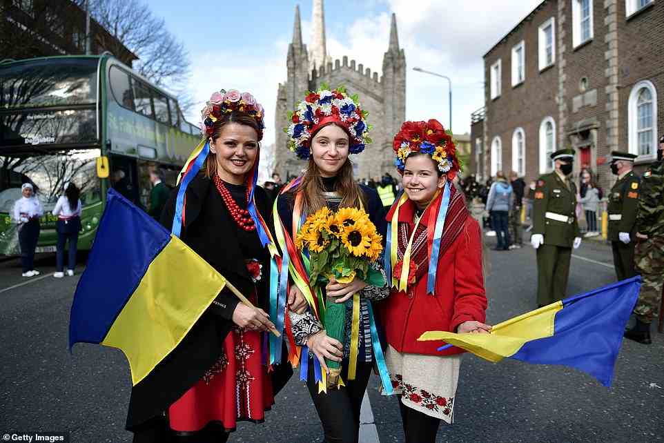Members of the local Ukrainian community pose for a photo with Ukrainian flags as people celebrate St Patrick's Day