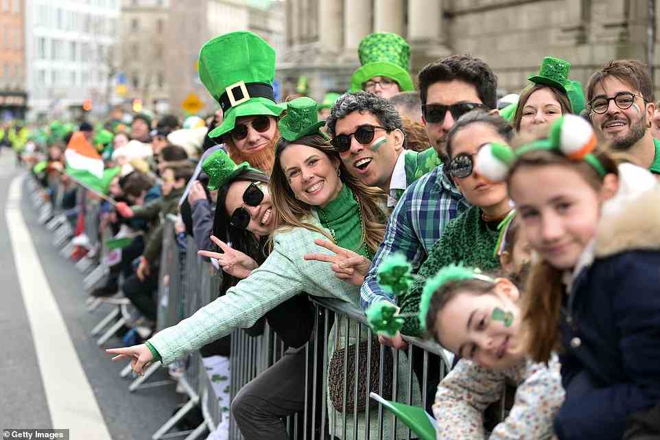 Spectators donning leprechaun hats and Irish face paint posed for the camera as they lined the streets during the St Patrick's Day parade