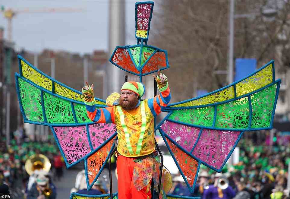 A performer donning an elaborate, colourful costume is seen travelling through the streets during the annual St Patrick's Day Parade