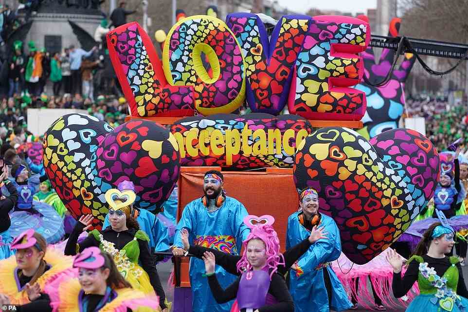 Performers wearing colourful outfits travelled through the streets with a giant 'love' balloon during the St Patrick's Day event today