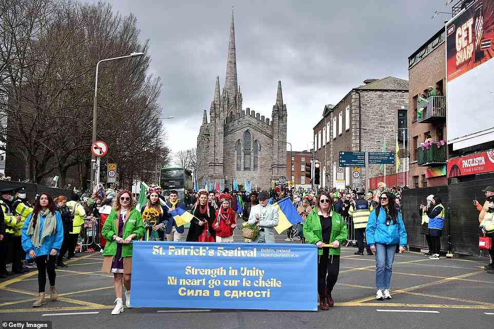 People hold a banner with a message of support to the people of Ukraine during the St Patrick's Day parade