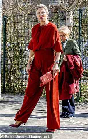 Die Mutter von drei Kindern war das Bild der Eleganz in einem Paar roter Zigarettenhosen, kombiniert mit einer passenden Bluse und einem burgunderfarbenen Wollmantel, als sie an der Veranstaltung teilnahm