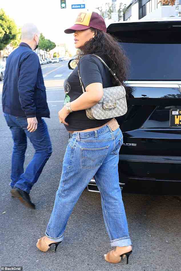 Zeigt ihren Bauch: Die neunmalige Grammy-Preisträgerin entblößte einen Blitz ihres Bauches in dem schwarzen Grafik-T-Shirt, das sie mit der Low-Rise-Blue-Jeans kombinierte