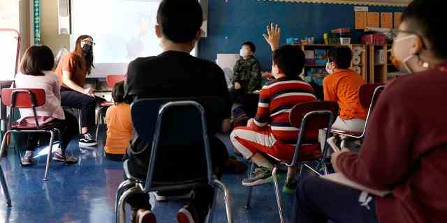 Ein Lehrer erteilt maskierten Schülern in ihrem Klassenzimmer an der Yung Wing School PS 124 am 27. September 2021 in New York City Unterricht.