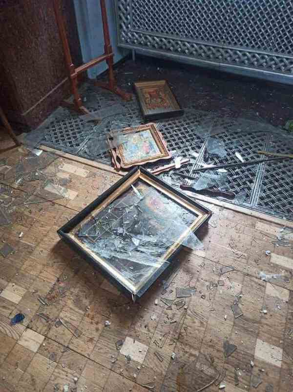 Religious artwork on the floor in broken frames.