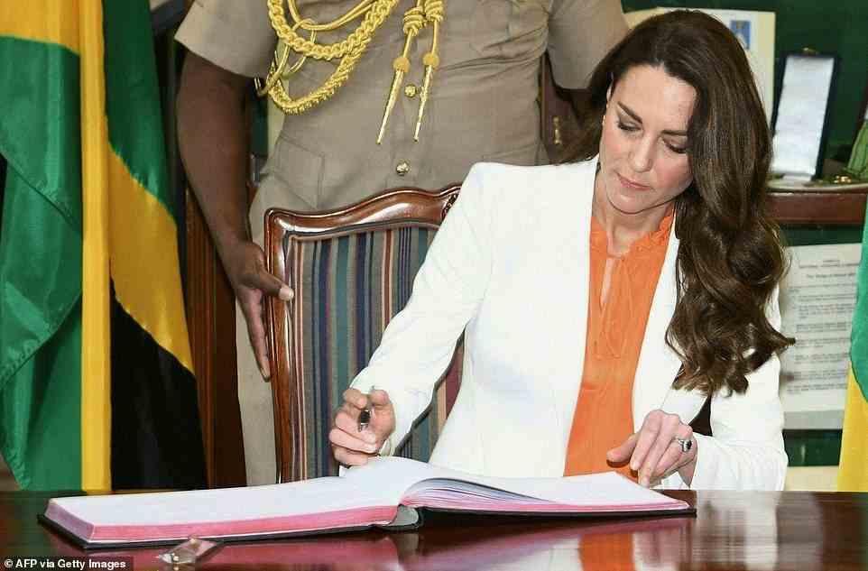 Kate Middleton, Duchess of Cambridge, signs the visitor's book at the Vale Royal, the official residence of the prime minister, in Kingston, Jamaica