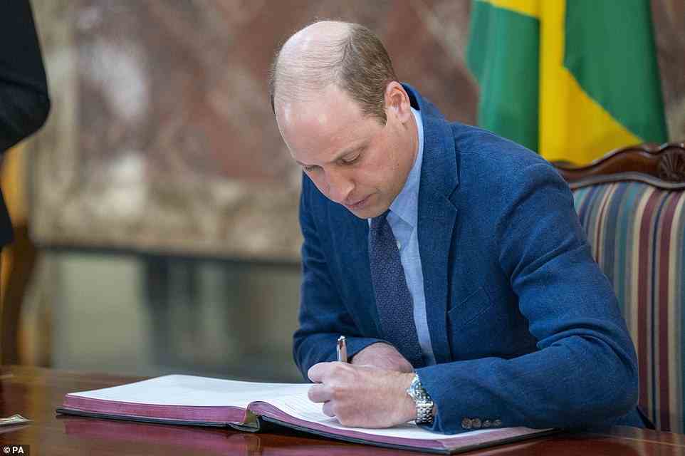 The Duke of Cambridge signs the visitor book during a meeting with the prime minister of Jamaica, Andrew Holness