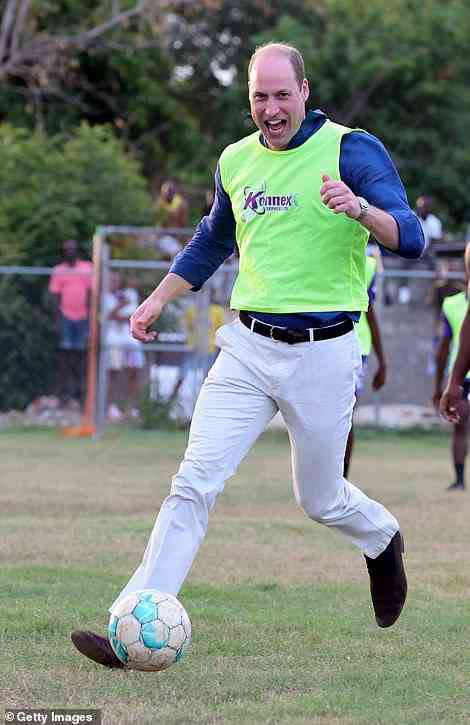 Prince William runs with a football as he participates in a game with local players in Trench Town on the first day of a tour of Jamaica