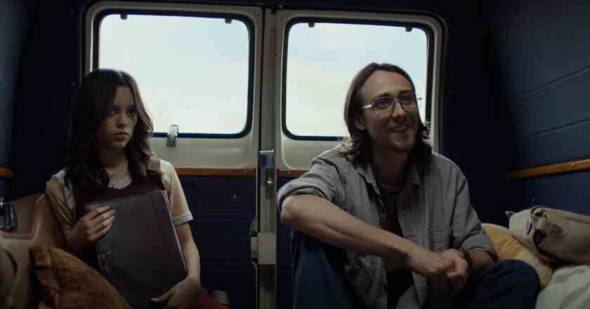 Eine junge Frau und ein Mann sitzen hinten in einem Lieferwagen.