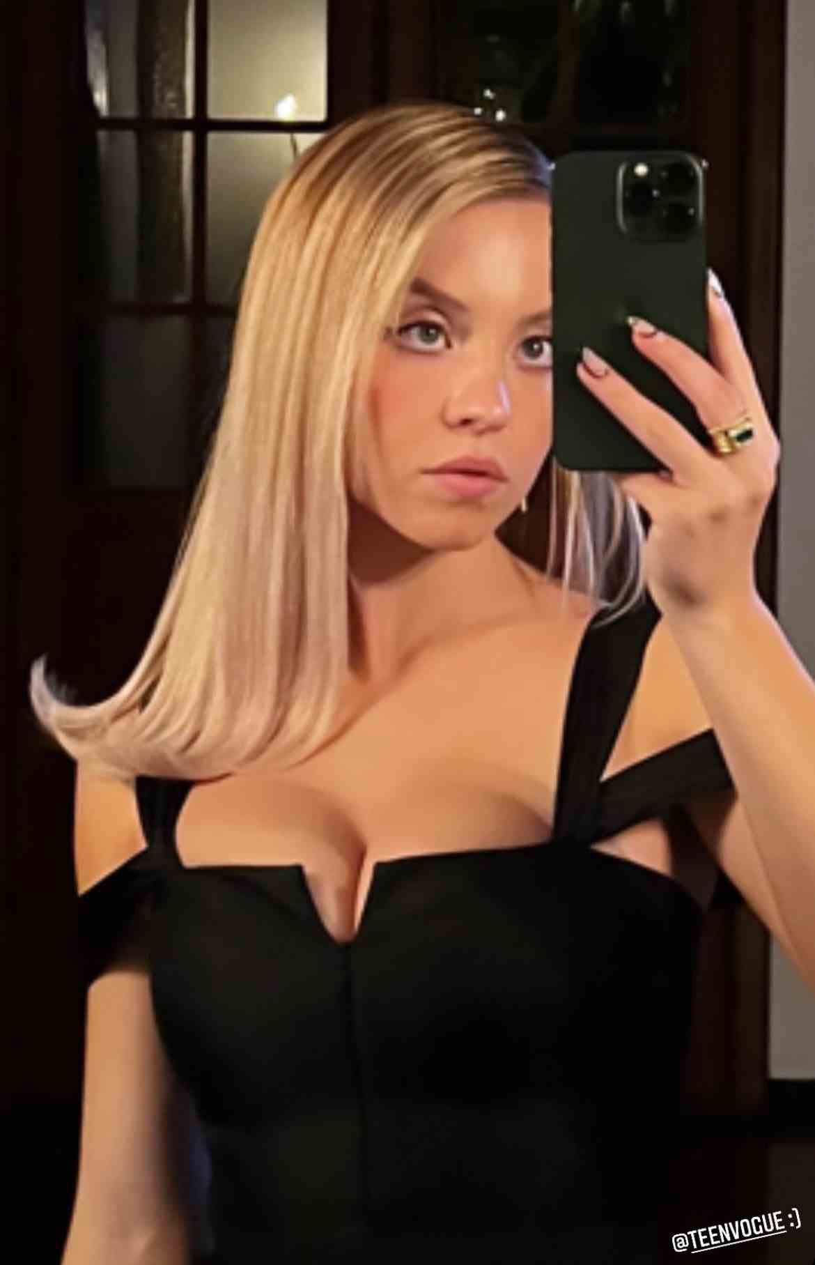 Sydney Sweeney macht ein Spiegel-Selfie in einem schwarzen Kleid