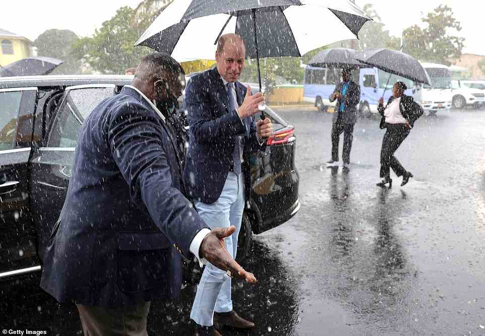 The Duke of Cambridge arrives in heavy rain as he visits Sybil Strachan Primary School in Nassau in the Bahamas today