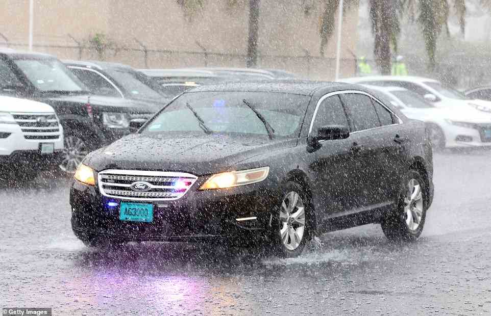 A car driving the Duke and Duchess of Cambridge arrives in the pouring rain at Sybil Strachan Primary School in Nassau today