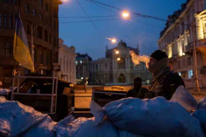 Ein ukrainischer Soldat raucht, als er und ein anderer Soldat hinter Sandsäcken und vor dem Gebäude des Nationalen Akademischen Theaters für Oper und Ballett in Odessa, Ukraine, Wache stehen, 24. März 2022. (AP Photo/Petros Giannakouris, Akte)