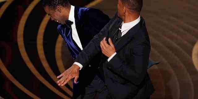 Will Smith (rechts) schlägt Moderator Chris Rock auf der Bühne, während er den Preis für den besten Dokumentarfilm bei den Oscars 2022 überreicht.