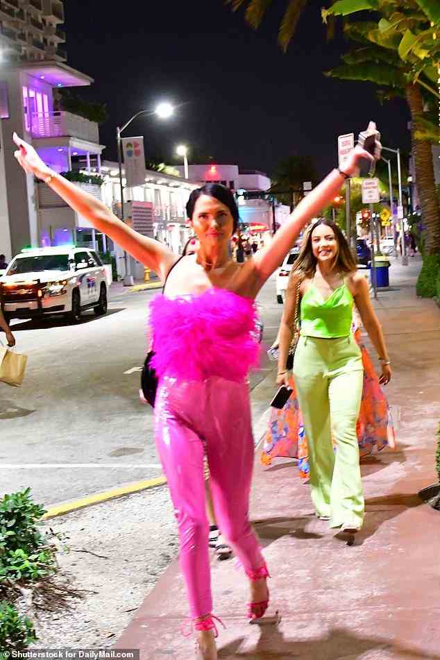 Zwei Spring Breaker, die scheinbar für Feierlichkeiten des Nachtlebens gekleidet sind, gehen am Sonntag durch die Straßen von South Beach in Miami