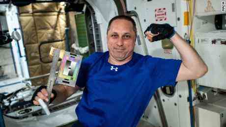 Der russische Kosmonaut Anton Schkaplerow posiert mit Lineal und Farbkarte für ein Weltraumarchäologie-Experiment.