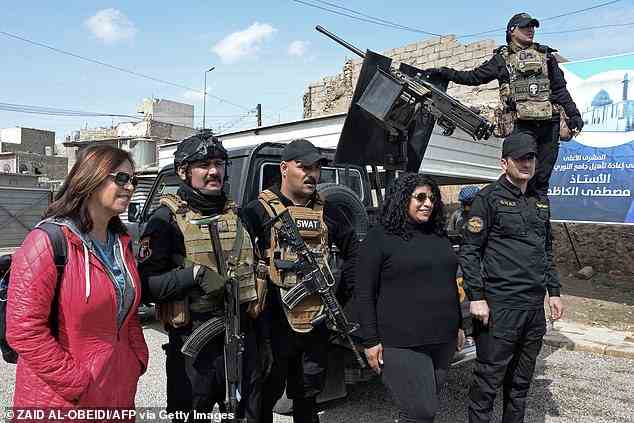 Die meisten westlichen Regierungen geben immer noch Reisewarnungen für den gesamten oder Teile des Irak heraus und weisen auf Risiken hin, die von Entführungen bis hin zu dschihadistischen Bombenanschlägen und Blindgängern aus mehreren Kriegen reichen.  Oben abgebildet sind Touristen, die für ein Foto mit irakischen Sicherheitskräften in Mossul posieren