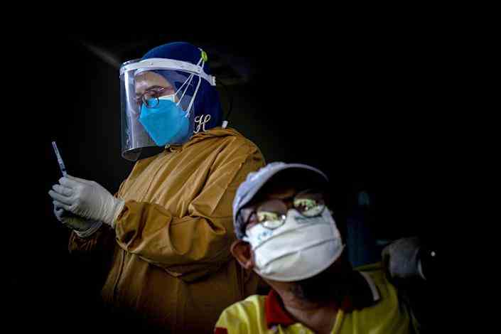Ein indonesischer Gesundheitshelfer bereitet am 6. August 2021 in Surabaya, Indonesien, den COVID-19-Impfstoff von Bio Pharma vor.