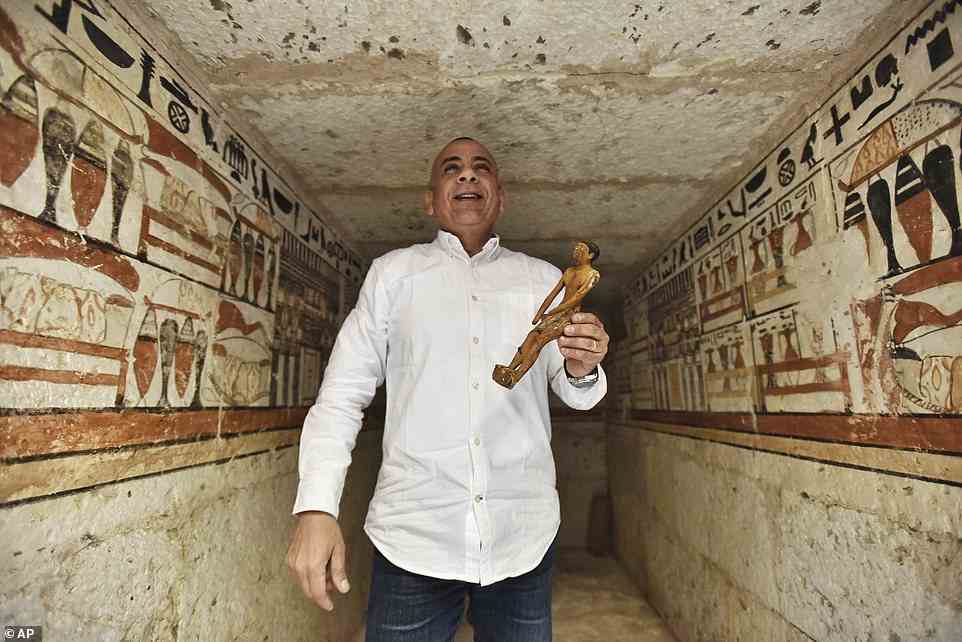 Mostafa Waziri, Generalsekretär des Obersten Rates für Altertümer, zeigt eine kleine Statue an einem mit Hieroglypheninschriften geschmückten Grab in einem kürzlich entdeckten Grab in der Nähe der berühmten Stufenpyramide in Sakkara, südlich von Kairo.