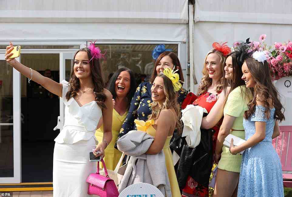Aber zuerst lass mich ein Selfie machen!  Eine Gruppe glamouröser Frauen posiert für ein Foto beim Scottish Grand National Ladies Day