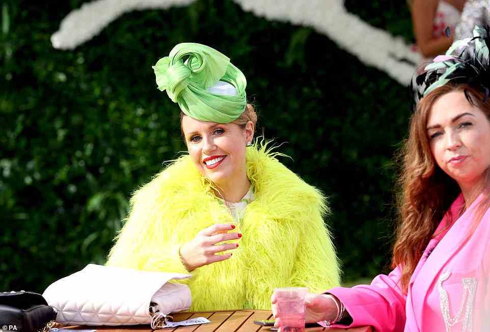 Eine Frau hob sich in einer flauschigen, leuchtend gelben Jacke und einem limonengrünen Hut von der Menge ab, während ihre Begleiterin in einem rosa Anzug ebenso lebhaft war