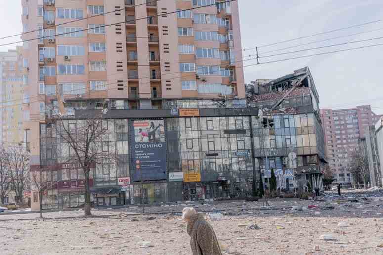 Eine Frau geht an einem Wohnhaus in Kiew vorbei, das am Samstagmorgen bei einem Raketenangriff beschädigt wurde.