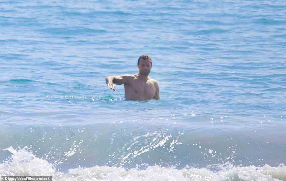 Water baby: The actor was seen taking a dip in the azure blue water of the Pacific Ocean as the waves crashed on to the expansive beach