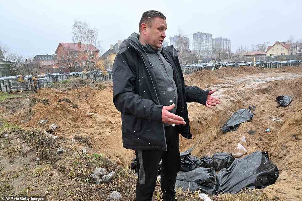 A man looks over a mass grave in Bucha. Western nations, including the UK, have accused Vladimir Putin and the Russian forces of carrying out 'despicable attacks' there