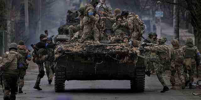 Ukrainische Soldaten steigen am Samstag, 2. April 2022, auf ein Kampffahrzeug außerhalb von Kiew, Ukraine. 