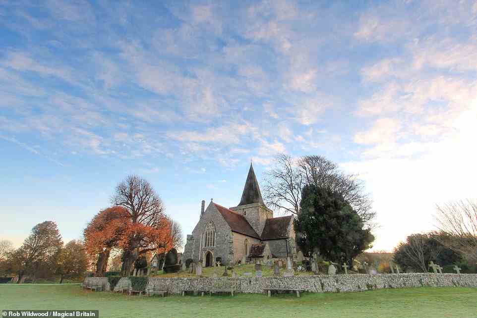 ALFRISTON CHURCH, EAST SUSSEX: There is a low mound next to this pretty church, thought to be of ancient pagan origin, the book says. According to the author, when builders tried to construct Alfriston church, the stones would be mysteriously moved to the mound overnight. Wildwood explains: 'Unsure whether it was the Devil’s work or the will of God, the builders consulted a wise man who had a vision of four oxen lying on the mound in the shape of a cross. This convinced them to build the church on the mound in an unusual equal-armed cross layout.' Coordinates: 50.8065, 0.1581