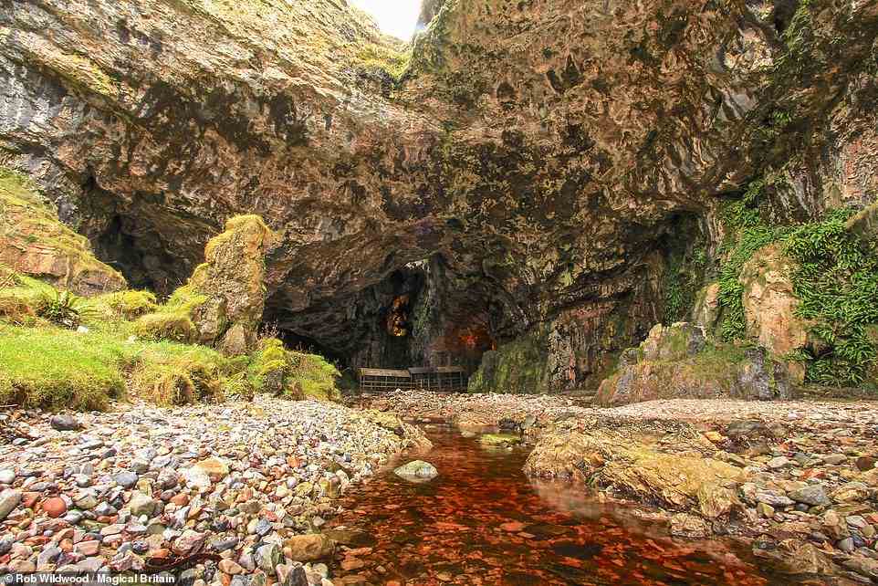 SMOO CAVE, DURNESS, SCOTLAND: 'Smoo Cave is one of Scotland’s largest caverns with a massive gaping mouth out of which the Smoo Burn flows,' the book explains. 'Inside are smaller chambers where a waterfall drops through a hole in the ceiling above. This hole was said to have been created by the Devil and a coven of witches who blew a hole in the ceiling to escape when they heard a cock crow and realized that the sun was rising.' Coordinates: 58.5637, -4.7205